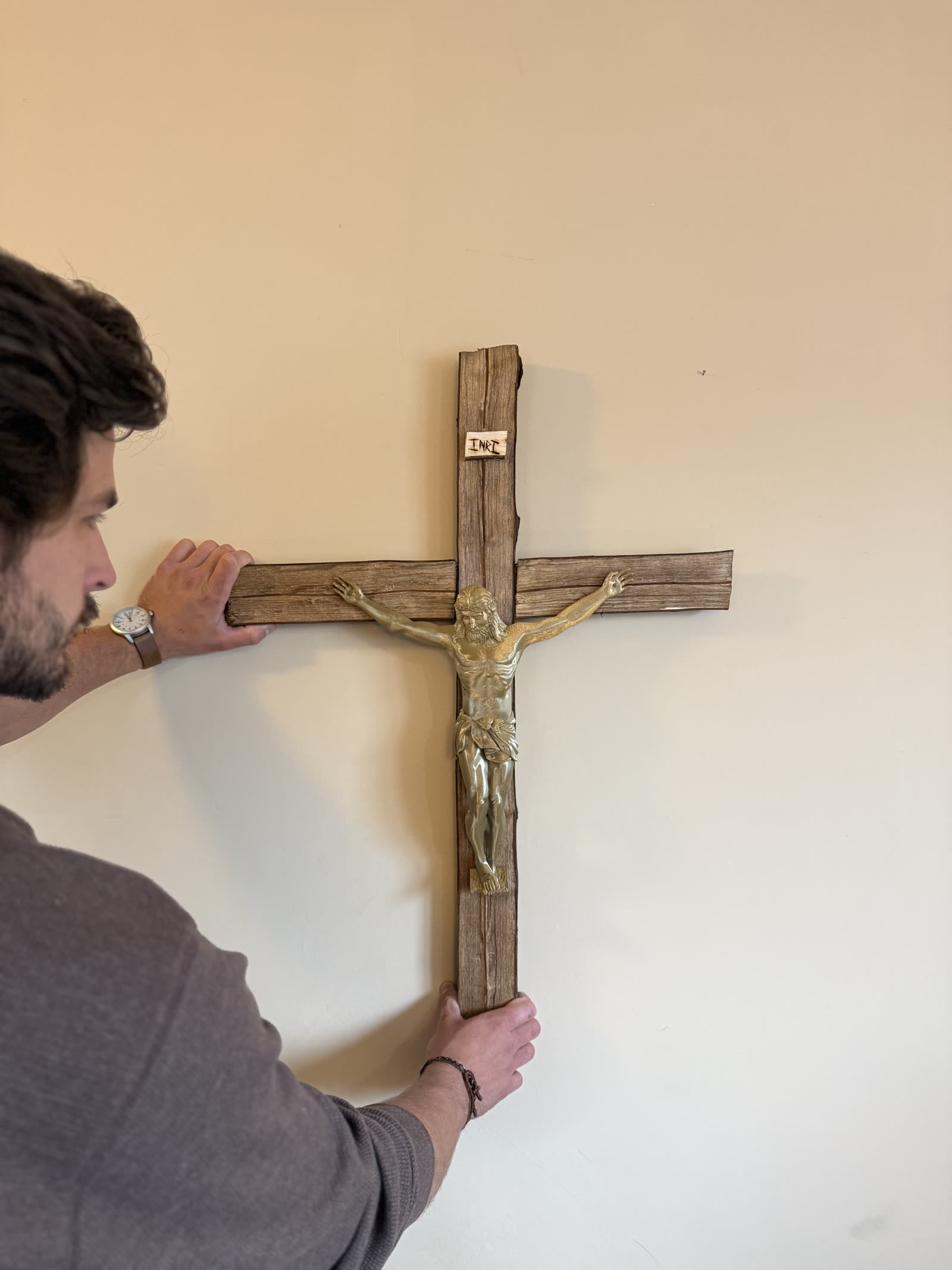 A handmade Dark Walnut crucifix with a brass-colored corpus